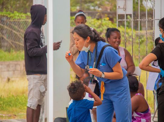 Melissa Xu blowing bubbles with children at a local health clinic in the Domican Republic