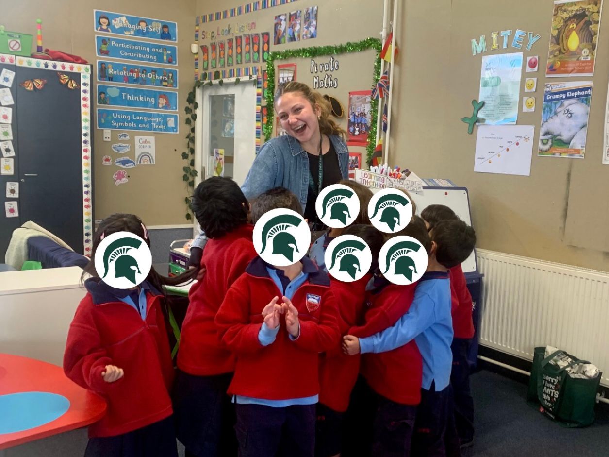 Stella standing with local school children in New Zealand