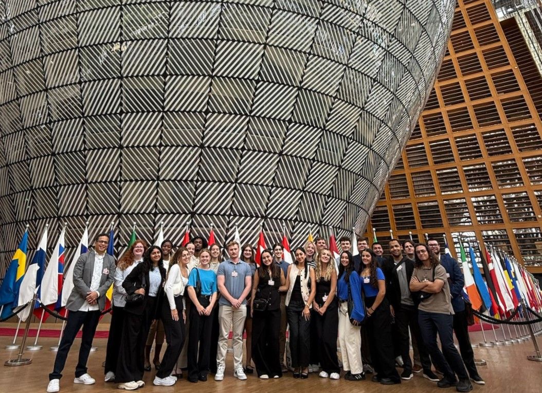 Group of students pose in front of flags at the European Council